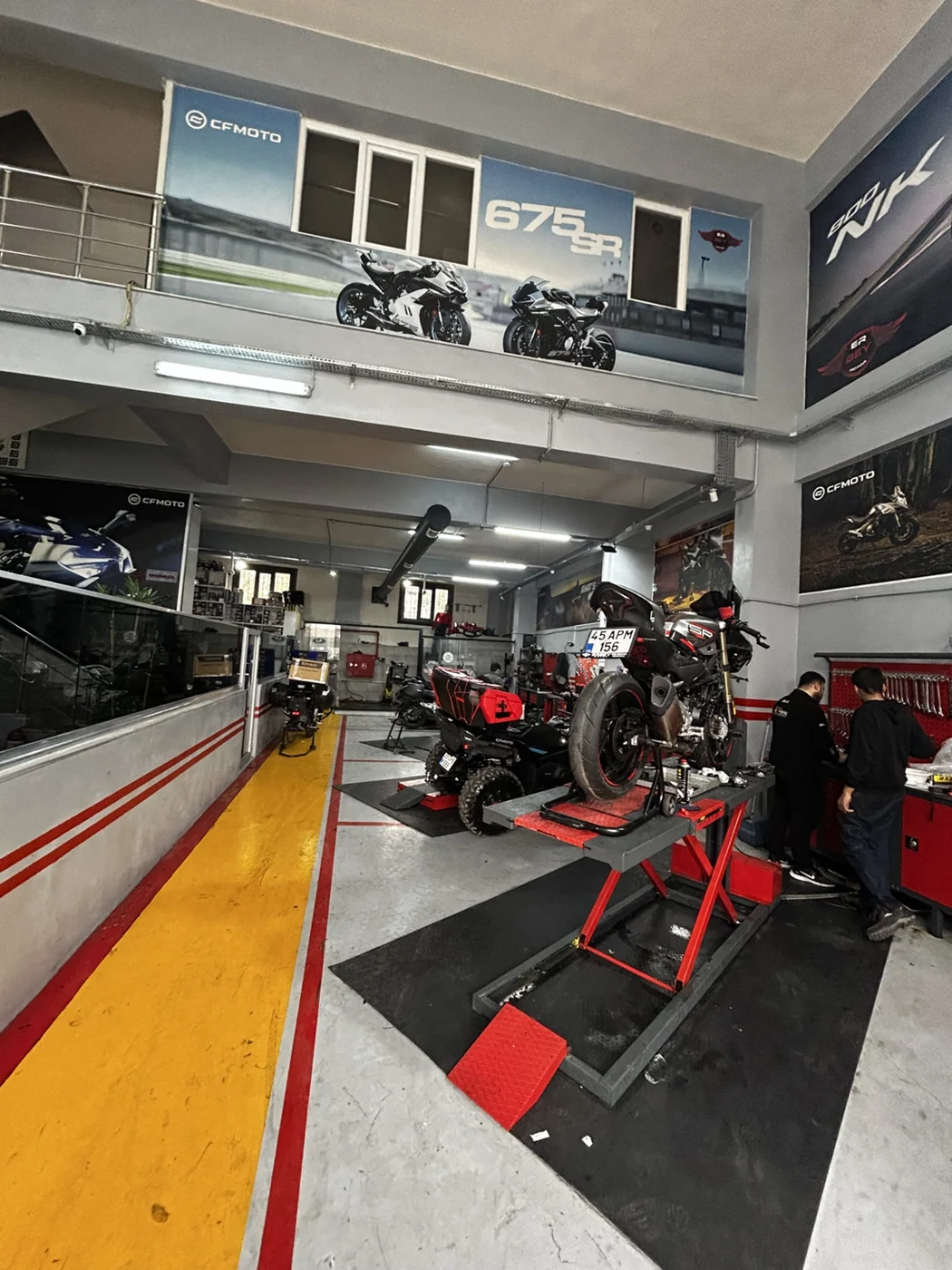 Erbey Motor servis atölyesinde lift üzerindeki motosikletler ve teknik ekip